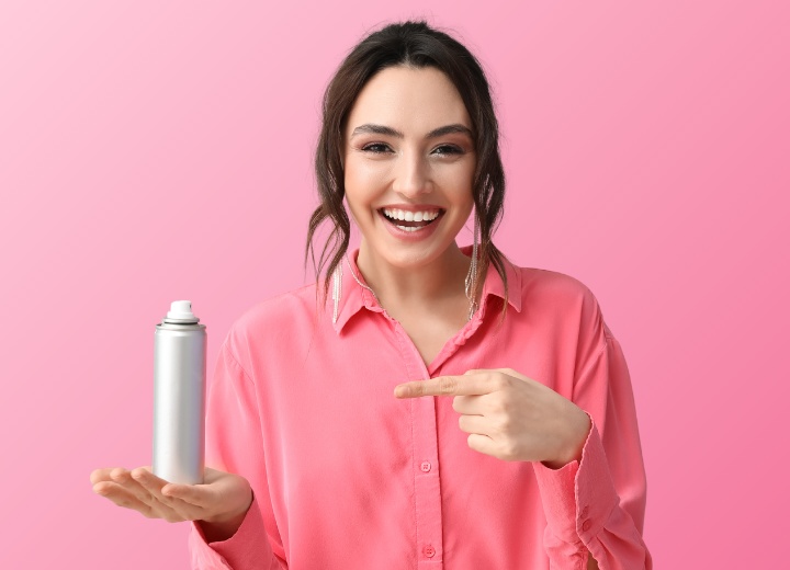Eine Frau mit einem Aerosol-Trockenshampoo in der Hand