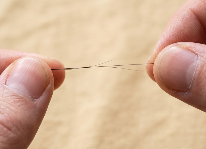 Haar, das aufgrund mangelnder Elastizit&auml;t bricht
