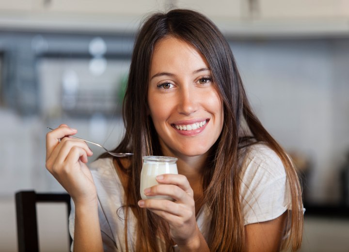 Brünettes Mädchen, das Joghurt isst